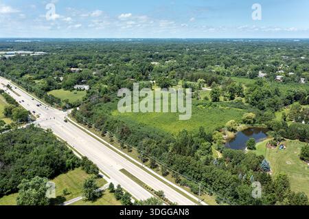 Luftaufnahme mit einem zum Verkauf stehenden Grundstück in der Nähe eines Wohnviertels in einem Vorstadtgebiet. Stockfoto