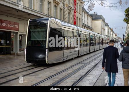 Tours, Frankreich - 26. November 2021: Moderne Straßenbahn fährt entlang der Rue nationale in der Nähe des Kaufhauses Galeries Lafayette in Tours France und schafft so ein geschäftiges Our Stockfoto