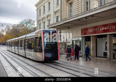 Tours, Frankreich - 26. November 2021: Moderne Straßenbahn fährt entlang der Rue nationale in der Nähe des Kaufhauses Galeries Lafayette in Tours France und schafft so ein geschäftiges Our Stockfoto