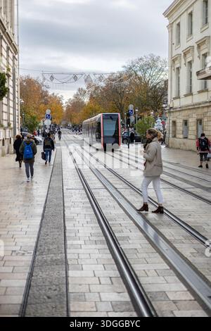 Tours, Frankreich - 26. November 2021: Moderne Straßenbahn fährt entlang der Rue nationale in der Nähe des Kaufhauses Galeries Lafayette in Tours France und schafft so ein geschäftiges Our Stockfoto