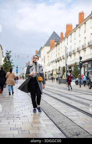Tours, Frankreich - 26. November 2021: Großer Blick auf die Einkaufsstraße Rue nationale mit Straßenbahnschienen und Weihnachtsgirlanden-Dekorationen in Tours France Stockfoto