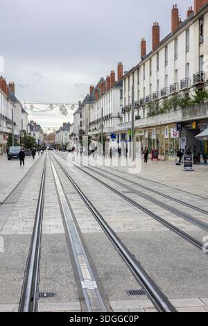 Tours, Frankreich - 26. November 2021: Großer Blick auf die Einkaufsstraße Rue nationale mit Straßenbahnschienen und Weihnachtsgirlanden-Dekorationen in Tours France Stockfoto