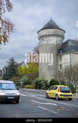 Tours, Frankreich - 26. November 2021: Blick auf den mittelalterlichen Stein Guise Turm des Chateau de Tours in der Nähe der Stadtstraße mit vorbeifahrenden Autos und herbstlichen Bäumen Stockfoto