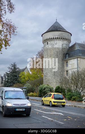 Tours, Frankreich - 26. November 2021: Blick auf den mittelalterlichen Stein Guise Turm des Chateau de Tours in der Nähe der Stadtstraße mit vorbeifahrenden Autos und herbstlichen Bäumen Stockfoto