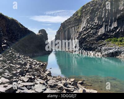 Stuðlafoss Wasserfall, eingerahmt von hoch aufragenden Basaltsäulen im Jokuldalur Valley, Ost-Island Stockfoto