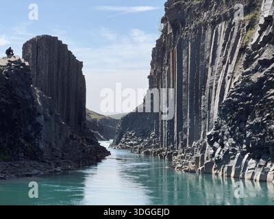 Stuðlafoss Wasserfall, eingerahmt von hoch aufragenden Basaltsäulen im Jokuldalur Valley, Ost-Island Stockfoto