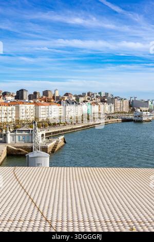 Santander, Spanien – 20. November 2021: Blick über das strukturierte weiße Keramikdach des Centro Botin auf die historischen Gebäude am Wasser und prome Stockfoto