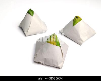 Drei Packungen traditioneller malaysischer Nasi-Lemak, verpackt in Papier und Bananenblatt auf weißem Hintergrund Stockfoto