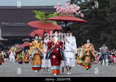 Farbenfrohe Geisha-Prozession mit roten Regenschirmen während des Aoi Matsuri in Kyoto, Kyoto, Japan Stockfoto