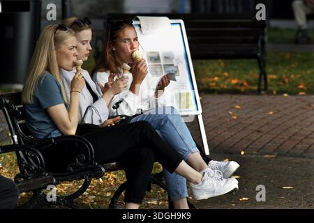 Frauen genießen Eis auf einer Bank im herbstlichen Naantali, Naantali, Finnland Stockfoto