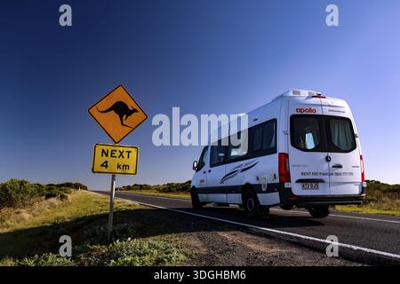 Ein Wohnmobil fährt entlang der Great Ocean Road vorbei an einem Känguru-Warnschild unter klarem blauen Himmel, Great Ocean Road, Victoria, Australien Stockfoto