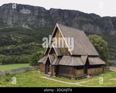 Oye, Innlandet, Norwegen, traditionelle Stabkirche vor steilen Bergen in ländlicher Umgebung, traditionelle Holzkirche vor beeindruckendem Stockfoto