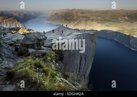 Preikestolen überragt den majestätischen Fjord mit Wanderern Stockfoto