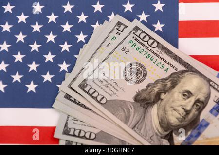 Hundert Dollar-Scheine auf dem Hintergrund der US-Flagge. Stockfoto