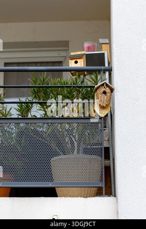 Ein Balkon mit einem Korbinsektenhotel und hölzernen Vogelhäusern zur Unterstützung der urbanen Tierwelt. Ein Konzept zur Schaffung einer kleinen Naturoase in der Stadt Stockfoto