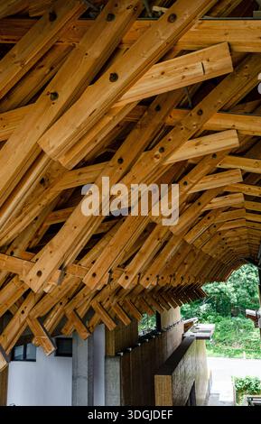 Blick auf eine hochkomplexe, ineinander greifende Holzdachkonstruktion. Die dichte Anordnung von Holzbalken zeigt traditionelle architektonische Schreinerei t Stockfoto