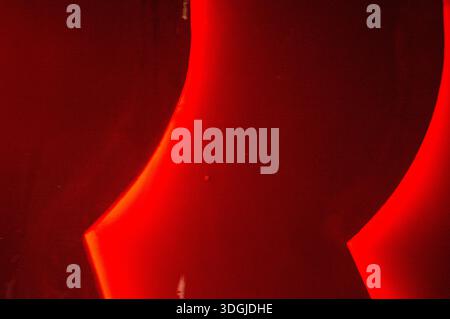 Abstrakte Komposition in tiefroten und schwarzen Farben mit geschwungenen Lichtformen. Der hohe Kontrast und die glatten Verläufe schaffen eine moderne, künstlerische Note Stockfoto