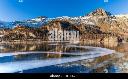 Panorama des gefrorenen Sees mit kurviger, undurchsichtiger Eislinie am Silsersee in St. Moritz, Graubünden, Schweiz Stockfoto