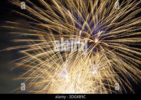 Buntes Feuerwerk explodiert am dunklen Nachthimmel während einer Feiertagsfeier und schafft eine magische Atmosphäre der Freude und des Glücks für Silvester Stockfoto