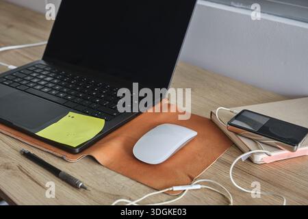 Laptop, Maus, Elektronik und Notebooks auf einem Schreibtisch mit Tageslicht Stockfoto
