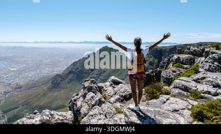 Atemberaubender Panoramablick vom Gipfel des Tafelbergs in Kapstadt, Südafrika. Frau reiste mit der Hand oben in den Himmel auf einem Berg Stockfoto