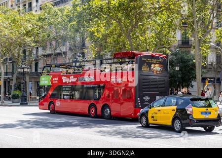 Barcelona Red Doppeldecker Sightseeing City Tour Bus auf Paseo de Gracia mit schwarz-gelbem Taxi dahinter, Spanien, Europa, 2025 Stockfoto