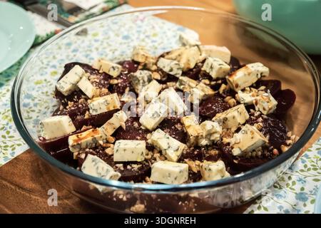 Nahaufnahme von Rote-Bete-Salat mit Blauschimmelkäse und Walnüssen, serviert in einer Glasschale auf dem Esstisch. Stockfoto