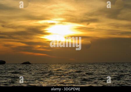 Die Sonne untergeht über den ruhigen Gewässern des Victoria-Sees in Uganda und strahlt goldene Töne über den See aus und unterstreicht die ruhige Schönheit Ostafrikas.“ Stockfoto