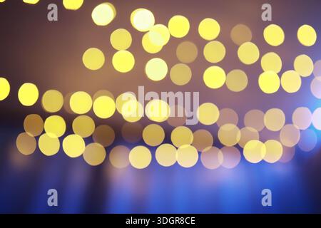 Abstrakter Bokeh-Hintergrund. Goldenes Bokeh kreist auf einem dunkelblauen Hintergrund. Überlagerte Ebenen. Stockfoto