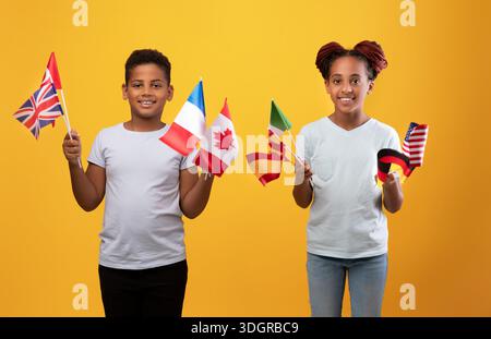 Glückliche schwarze Kinder posieren mit verschiedenen Fahnen Stockfoto