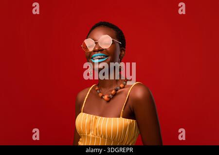 Happy attraktive schwarze Frau in Sonnenbrille und Sommer-Outfit Stockfoto