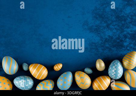 Farbenfrohe Ostereier mit blauen und gelben Mustern auf einer strukturierten blauen Oberfläche. 3D-Rendering Stockfoto