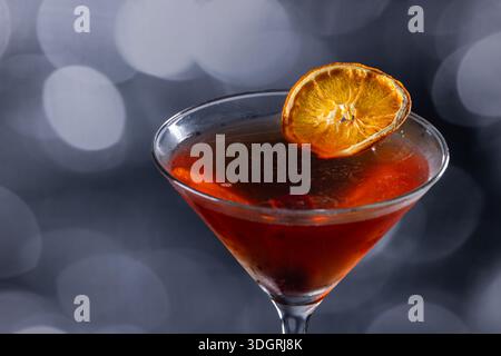 Whiskey-Cocktail oder manhattan serviert mit einer dehydrierten Orangenscheibe. Stockfoto