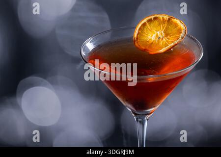 Whiskey-Cocktail oder manhattan serviert mit einer dehydrierten Orangenscheibe. Stockfoto