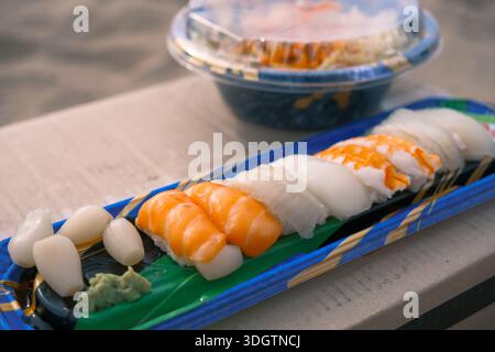 Abgepacktes Nigiri-Sushi mit Lachs und Tintenfisch, serviert in einem Plastiktablett unter natürlichem Tageslicht Stockfoto