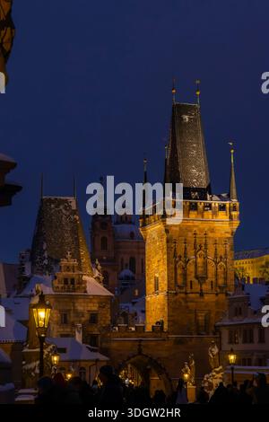 Historische Architektur und beleuchteter Karlsbrückenturm in der Abenddämmerung in Prag, Tschechien Stockfoto