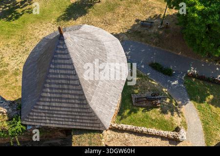 Mittelalterliches Schlossturmdach mit Holzschindeln und einer alten Kanone auf dem Gelände in Filakovo, Slowakei Stockfoto