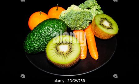 Auswahl an frischem Bio-Gemüse und Obst einschließlich Avocado Kiwi Brokkoli und Karotten für einen gesunden Lebensstil. Stockfoto