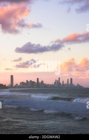 Blick auf die Skyline von Surfers Paradise während eines Sonnenuntergangs am rosa Himmel von Burleigh Heads, Gold Coast, Queensland, Australien. Stockfoto