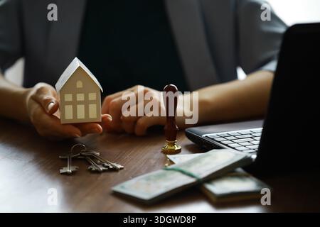 Der Immobilienmakler sprach über die Bedingungen des Kaufvertrags und bat den Kunden, die Dokumente zu unterzeichnen, um den Vertrag legal zu machen, Hom Stockfoto