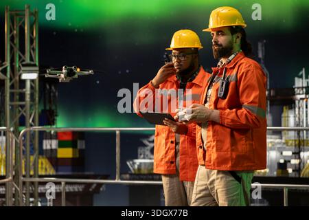 Drohne, die von Mitarbeitern des Bohrschiffs gesteuert wird, um die Bedingungen der externen Pipeline zu überwachen. Teamkollegen auf der Offshore-Plattform verwenden UAV-Kamera, um potenzielle Leitungsundichtigkeiten zu erkennen Stockfoto