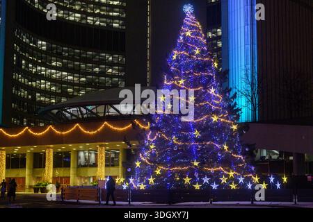 Toronto, ON, Kanada 20. Dezember 2025, großer Weihnachtsbaum, hell beleuchtet mit blauen und goldenen Lichtern am Nathan Phillips Square während Toronto Cavalcad Stockfoto