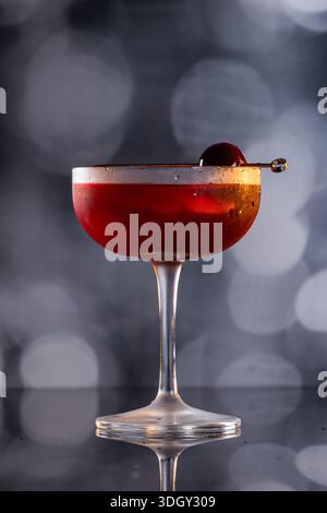 Manhattan Cocktail serviert mit einer Bordeauxkirsche und einem Orangengeschmack Stockfoto