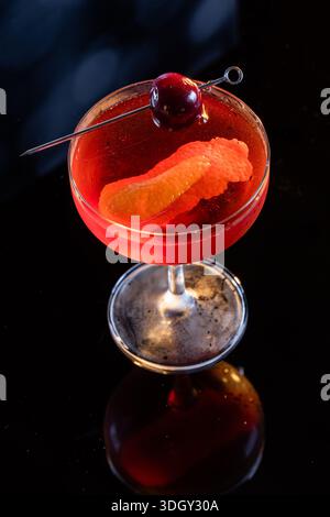 Manhattan Cocktail serviert mit einer Bordeauxkirsche und einem Orangengeschmack Stockfoto