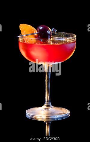Manhattan Cocktail serviert mit einer Bordeauxkirsche und einem Orangengeschmack Stockfoto