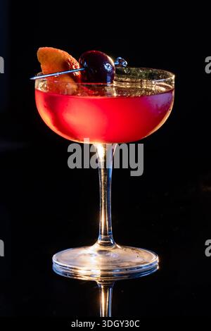 Manhattan Cocktail serviert mit einer Bordeauxkirsche und einem Orangengeschmack Stockfoto