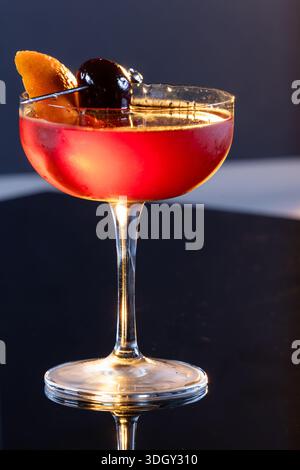 Manhattan Cocktail serviert mit einer Bordeauxkirsche und einem Orangengeschmack Stockfoto