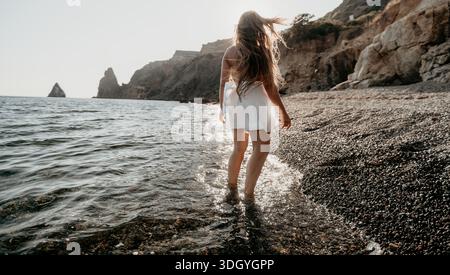 Frau, die bei Sonnenuntergang am Strand läuft Stockfoto