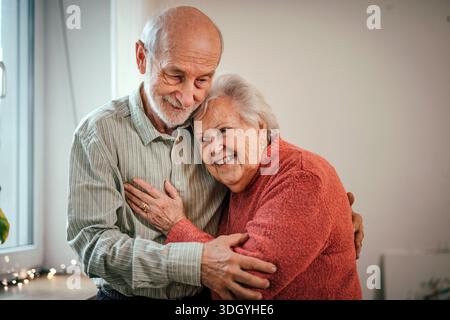 Liebevolles Seniorenpaar, das in Innenräumen gute Zeit miteinander verbringt. Stockfoto