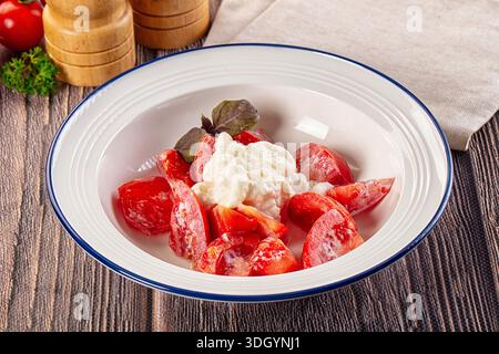Salat mit Stracciatella-Käse und Tomaten Stockfoto